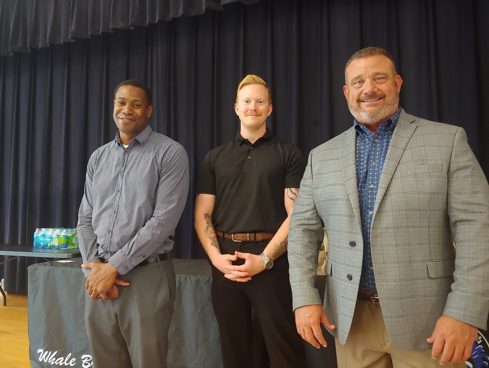 Three people standing together in a school